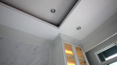 Modern bir evde beyaz ahşap duvarlar ve beyaz dolaplar.