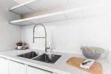 Mutfakta beyaz ışık olan temiz lavabo, evde temizlik ve hijyen kavramı.