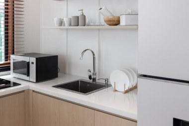 Minimum düzeyde beyaz bir mutfakta mikrodalga fırın.