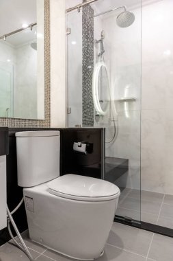 Banyo ve sifon tuvaletinde cam kapı, beyaz fayans odası.