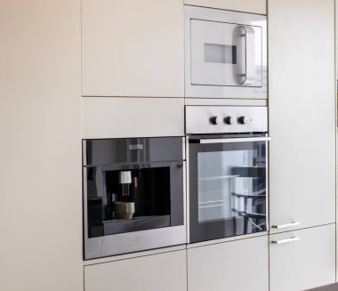 Modern apartmanda mikrodalga fırın ve mutfak mobilyası.