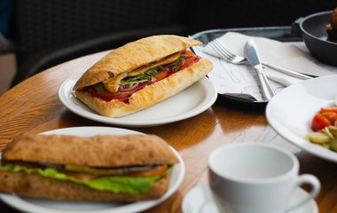 Full table of delicious and different dishes in cafe with cup of coffee in white dinnerware.
