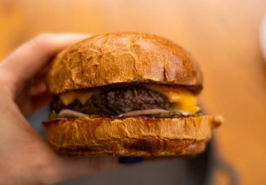 Fast food restoranında pirzolalı büyük ve sulu bir hamburger..
