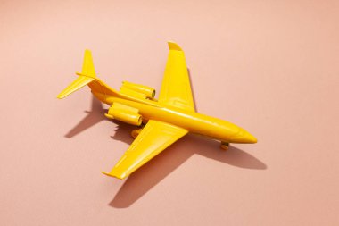Pembe arka planda sarı oyuncak uçak