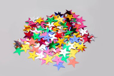 Gri yüzeyde izole edilmiş yıldız şekilli konfeti