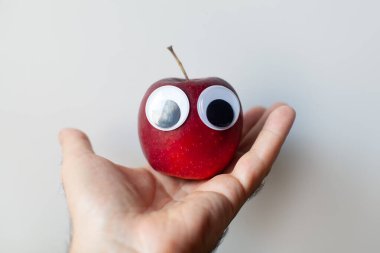 Palmiye ağacında gözleri olan kırmızı elma