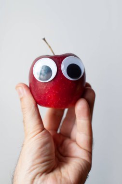 Palmiye ağacında gözleri olan kırmızı elma