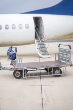 Uçağın önüne boş bagaj vagonu.