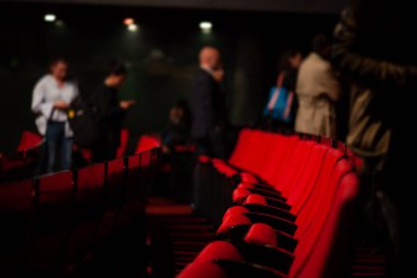 Seyirciler tiyatroya geliyor ve oturuyorlar.