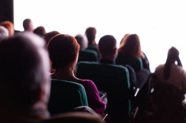 İnsanlar tiyatroda oyun izliyorlar.