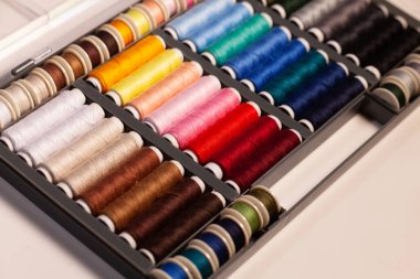 Birçok renkli dikiş iplikleri makaraların üzerine