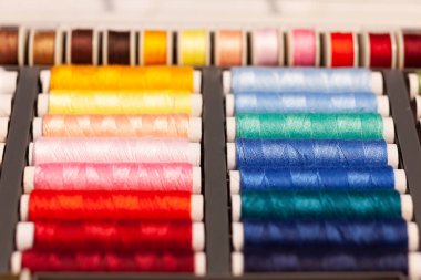 Birçok renkli dikiş iplikleri makaraların üzerine