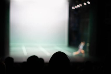 İnsanlar tiyatroda oyun izliyorlar.