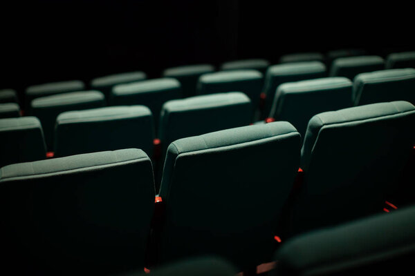 vacant green theater seats in dark room