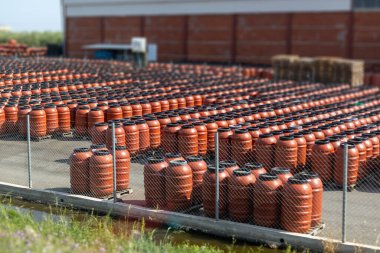 Endüstriyel ortamda güneşli bir günde sayısız konteynırla dolu bir depo.