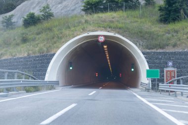 İçinde ışık olan bir tünele giren yol.