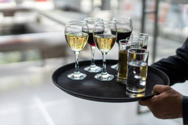 Garson zarif bir etkinlikte beyaz şarap ve su servisi yapıyor.