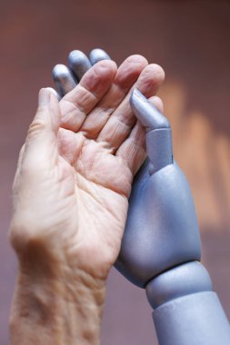 Robotik el yaşlı insanın elini tutuyor