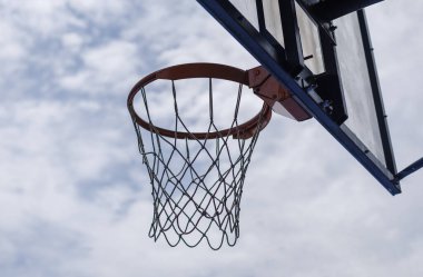 Güneşli bir günde bulutlu gökyüzüne karşı basketbol potası