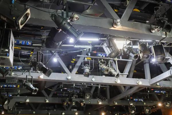 Canlı performans sırasında bir tiyatro salonunun tavanından sarkan ışıklandırma ekipmanları.