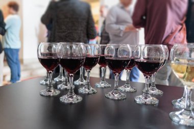 Öğleden sonra sosyal bir toplantıda servis edilen kırmızı şarapla dolu şarap kadehleri.