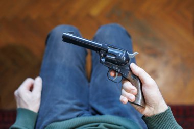 Depresyonda bir adam silaha bakıyor, intiharı düşünüyor.