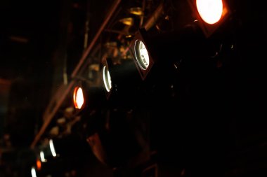 Parlak sahne ışıkları bir tiyatrodaki performans alanını aydınlatır.