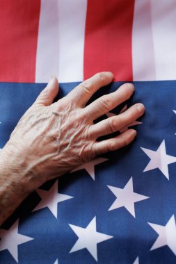 Bir Amerikan bayrağının üzerinde dinlenen yaşlı bir el yansıma ve vatanseverlik anında