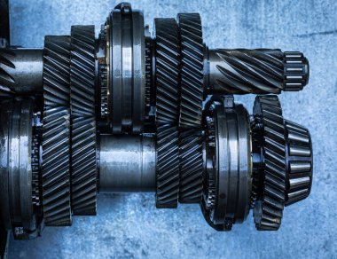 Automatic transmission gearset with cogwheels and bearings on a workbench ready for repair. Industrial mechanical background