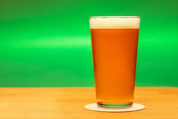 Full Shaker Pint Glass Amber Ale Beer Wooden Table Green — Stockfoto
