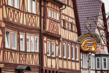 Ochsenfurt, Almanya - 8 Mayıs 2019: Backerei (Fırın) kafe tabelası ve arka planda Eski Kentin yarım keresteli evlerinin simgesi