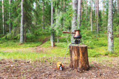 Ormanda kamp yaparken sıvı yakıtlı ocağın üzerinde Türk usulü kahve demlemek.