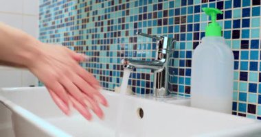 Kadın antibakteriyel sabun ve suyla titizlikle ellerini yıkıyor. Coronavirus COVID-19 hastalığının yayılmasına karşı temel koruma önlemlerini uyguluyor.