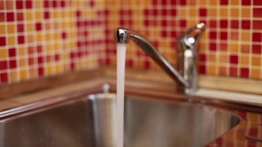 Bir cam ile mutfak musluk içme suyu dolduruyor