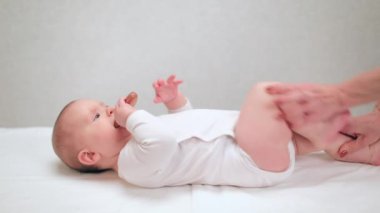 Altı aylık bebek, pediatri kliniğinde osteopatik veya kayropraktik tedavi görüyor. El terapisti, kalça displazisini önlemek için çocukların bacaklarını manipüle ediyor.
