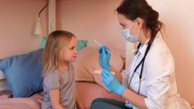 Çocuk doktoru Coronavirus tecridi sırasında tükürük testi örneği alıyor.