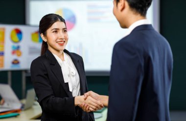 Milenyum profesyonel başarılı erkek işadamı ve kadın iş kadını resmi iş elbisesi içinde el sıkışıyorlar iş anlaşması sağlandı