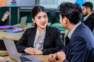 Milenyum Asyalı profesyonel erkek iş adamı akıl hocası resmi iş elbisesi içinde yeni bayan iş kadınlarına danışmanlık yapıyor dizüstü bilgisayarla çalışıyor..