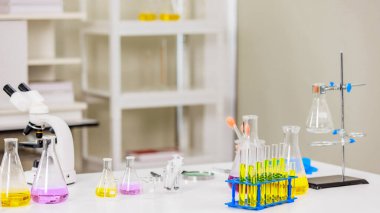 Cam test tüpleri, çeşitli renkli sıvılar, masasında mikroskop, korumak için aşı yapmak için çalışma, laboratuvar geçmişi. Kimyasal laboratuvar araştırma ve geliştirme bilim konsepti.