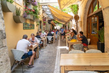 Yunanistan 'ın Girit kentindeki Rethymno kentindeki Xanthoudidou sokağı gibi rahat sokaklarda dolu teraslar