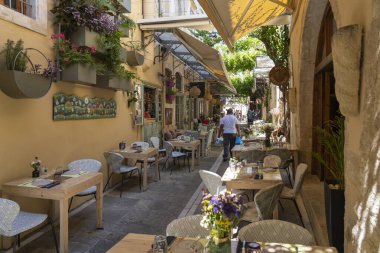 Yunanistan 'ın Girit kentindeki eski Rethymno kentindeki Radamathios caddesinde bir sürü çiçek ve bitkiye sahip samimi küçük restoranlar