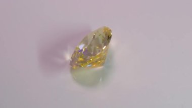 Limon renginde, Armut şeklinde, Yedili Pendeloque dizaynı olan Kübik Zirkonya 'nın tam 360 derecelik bir videosu, beyaz fotografla kaplı bir pikabın üzerine yerleştirilmiş.