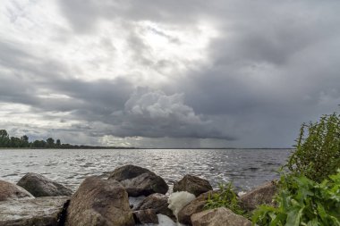 Sert rüzgar ve kötü hava Hollanda, Harderwijk yakınlarındaki Wolderwijd 'in suyundaki kayalar arasında köpüğe neden olur.