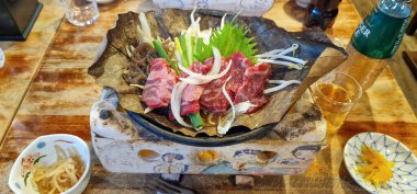 Japonya 'nın Takayama kentindeki bir restoranda, hazır muz yaprağı üzerinde, sebzelerle ve çeşitli et çeşitleriyle karıştırmanın Japonca yolu.