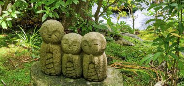 Japonya, Kamakura 'daki Hase-dera Tapınağı' ndaki bu Japon tapınağı bahçesinde üç neşeli Buda heykeli yan yana.