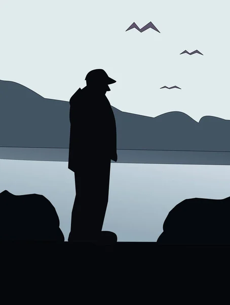 The silhouette of a man watching the sea at dawn