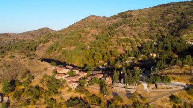 Geleneksel terk edilmiş ortaçağ kırsal köyü Phicardou (Fikardou), Lefkoşe, Kıbrıs Rum Kesimi 'nin hava gün batımı drone görüntüleri. Yukarıdan terk edilmiş seramik seramik kiremitli çatı evleri ve kilise manzarası kurun