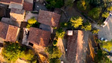 Geleneksel terk edilmiş ortaçağ kırsal köyü Phicardou (Fikardou), Lefkoşe, Kıbrıs Rum Kesimi 'nin hava gün batımı drone görüntüleri. Terk edilmiş seramik seramik kiremitli çatı evleri ve kilise yukarıdan.