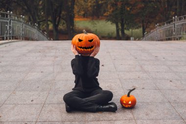 Cadılar Bayramı. Balkabağı. Sabah şehrinin sokaklarında kafasında balkabağı olan bir adam.