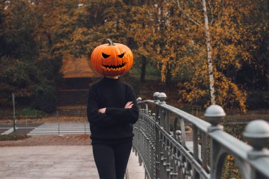 Cadılar Bayramı. Balkabağı. Sabah şehrinin sokaklarında kafasında balkabağı olan bir adam.